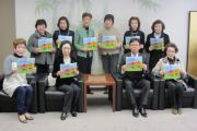 絵本を手にする国際ソロプチミスト京都-西山のメンバーと市長の記念写真