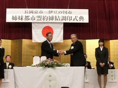 姉妹都市盟約締結記念式典で両市長が握手している写真