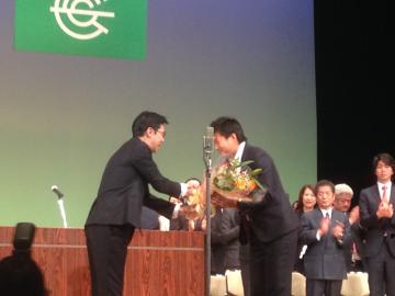 成人式にサプライズゲストで登場した海堀あゆみ選手に花束を渡す市長の写真