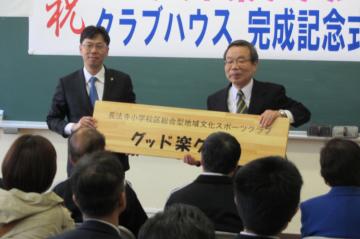 長法寺小総合型地域文化スポーツクラブの看板を若林会長と手にする中小路市長