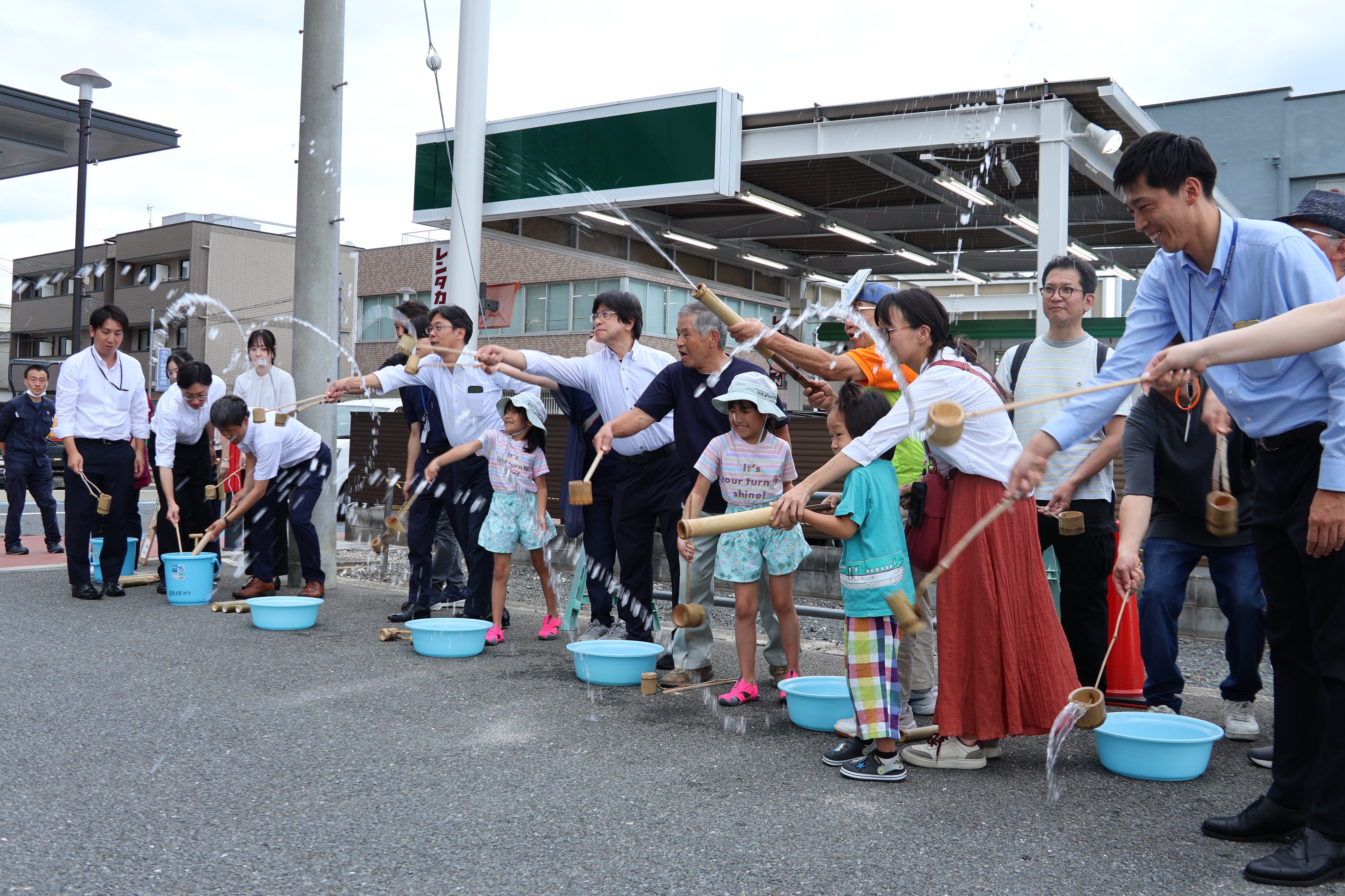 市役所南側駐車場前で打ち水