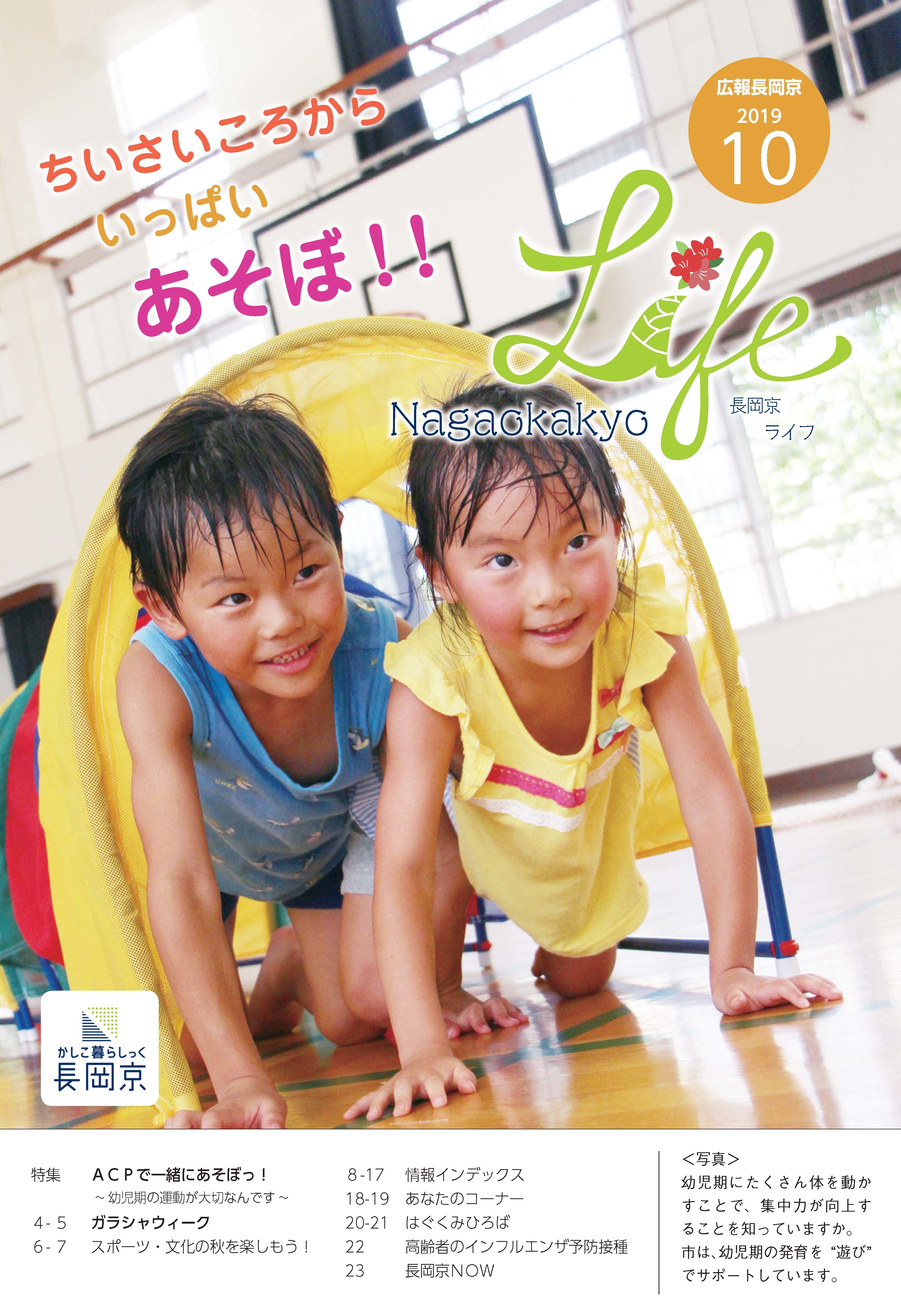 広報長岡京10月号の表紙。体育館内で遊ぶ子ども二人。少し汗ばみながら黄色いトンネルを笑顔でくぐりぬけて運動