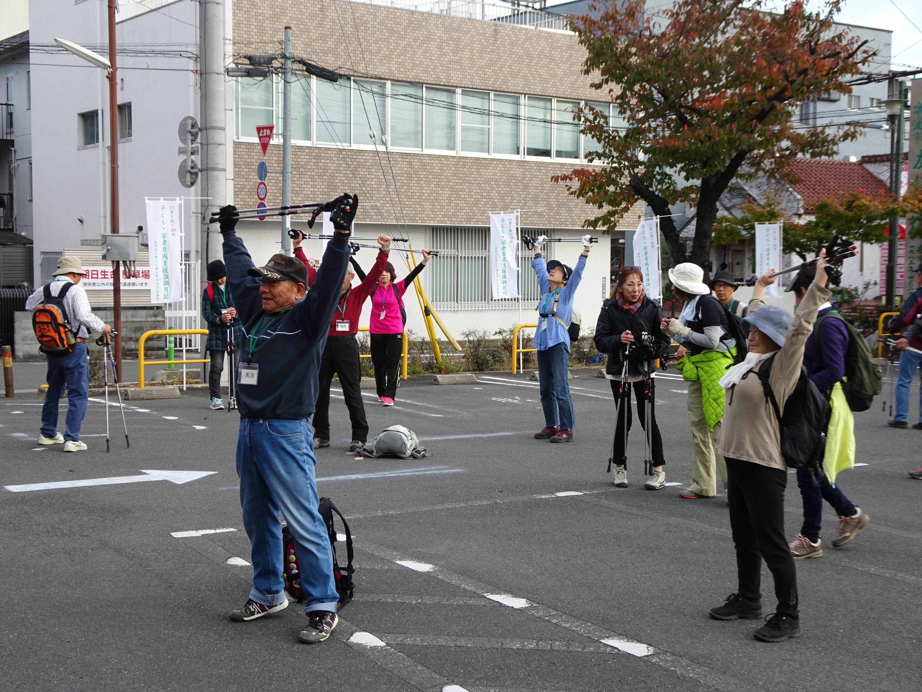 市役所に到着し、ポールを使ってストレッチする参加者