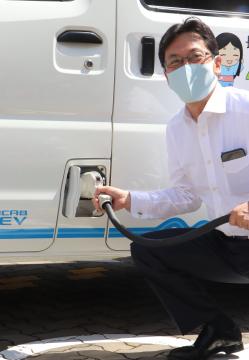 中小路市長が電気自動車にプラグを差し込んでいる写真