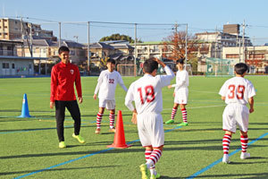 生徒たちの動きを見て声をかける麻田選手の写真