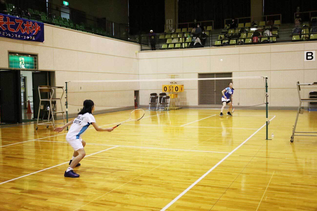 選手とシングルで真剣にプレーする小学生。の写真