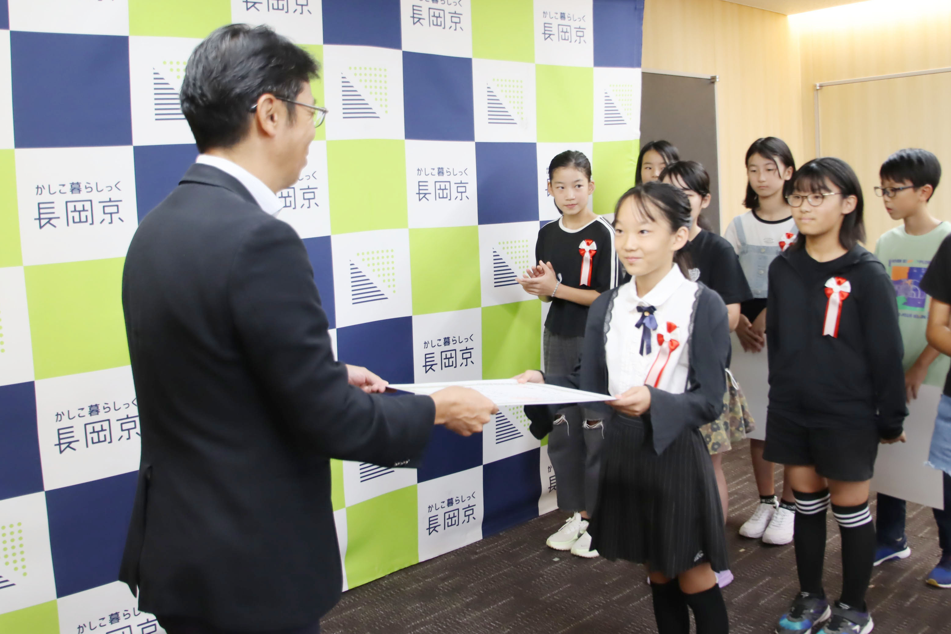市長が小学生に表彰状を渡す様子