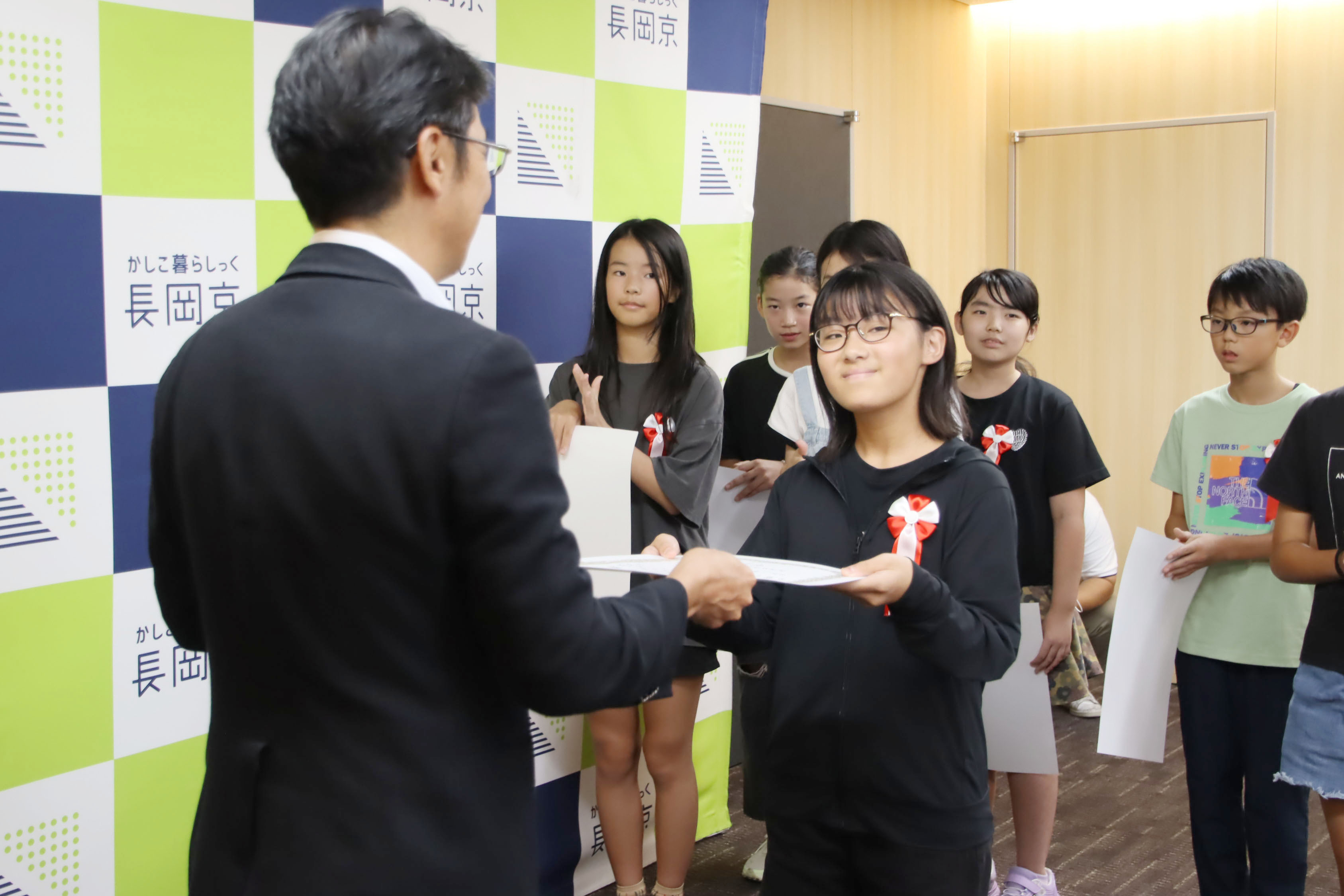 市長が小学生に表彰状を渡す様子