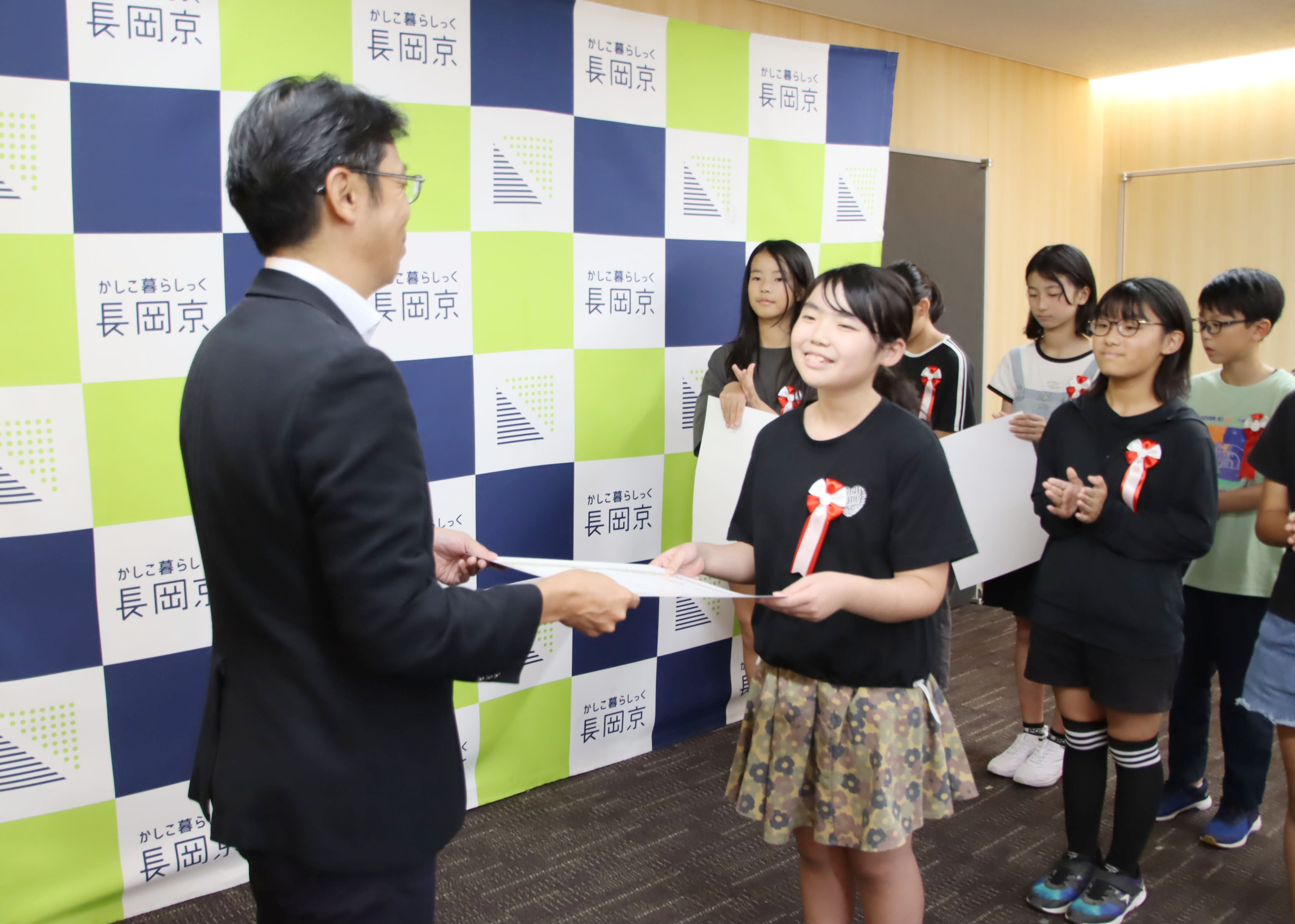 市長が小学生に表彰状を渡す様子
