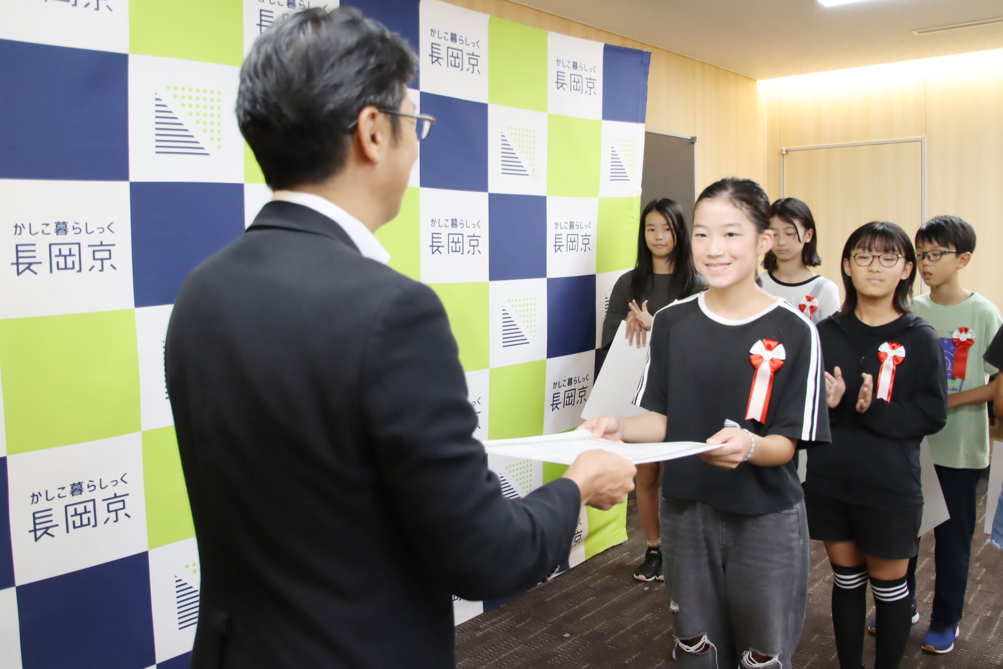 市長が小学生に表彰状を渡す様子
