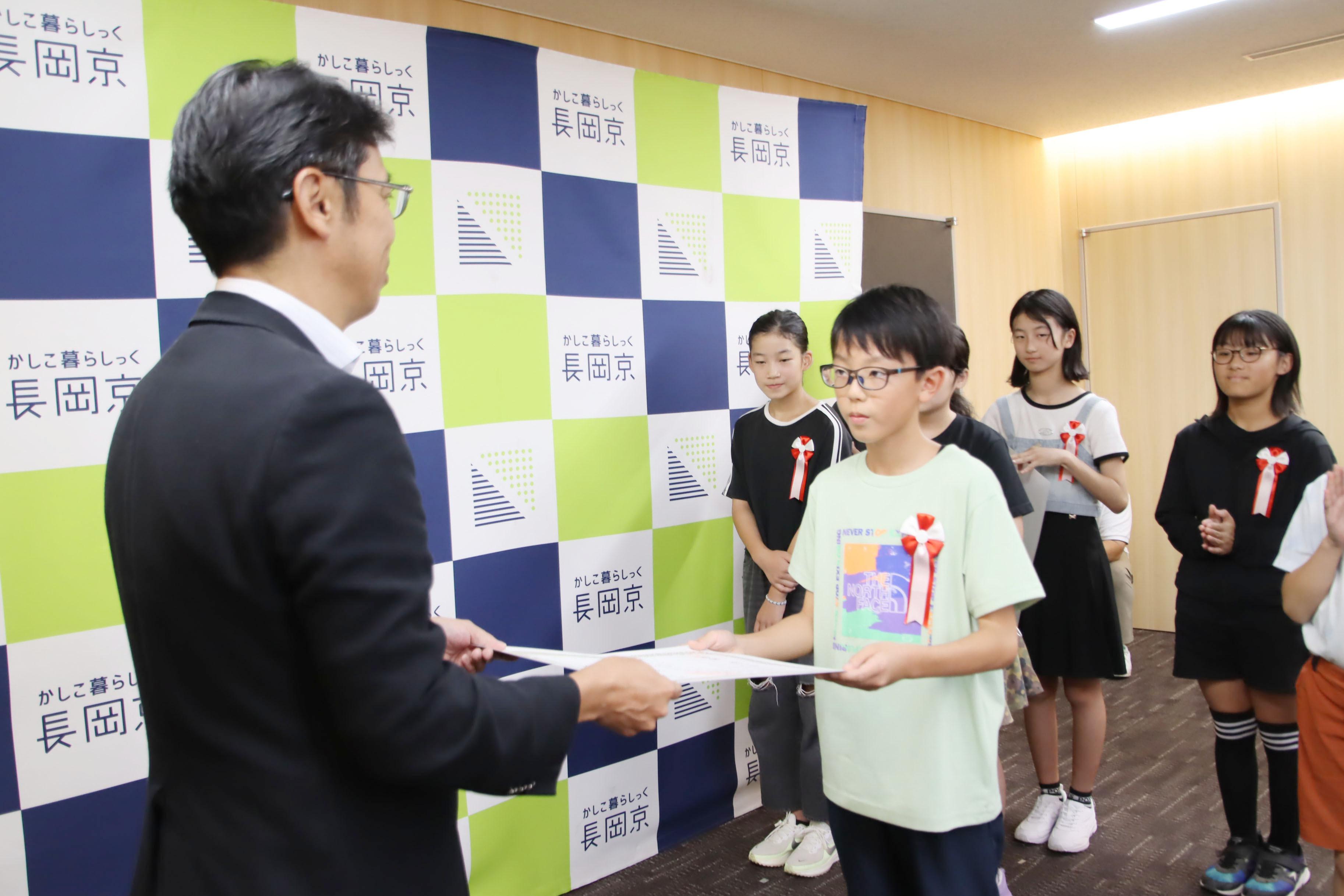 市長が小学生に表彰状を渡す様子