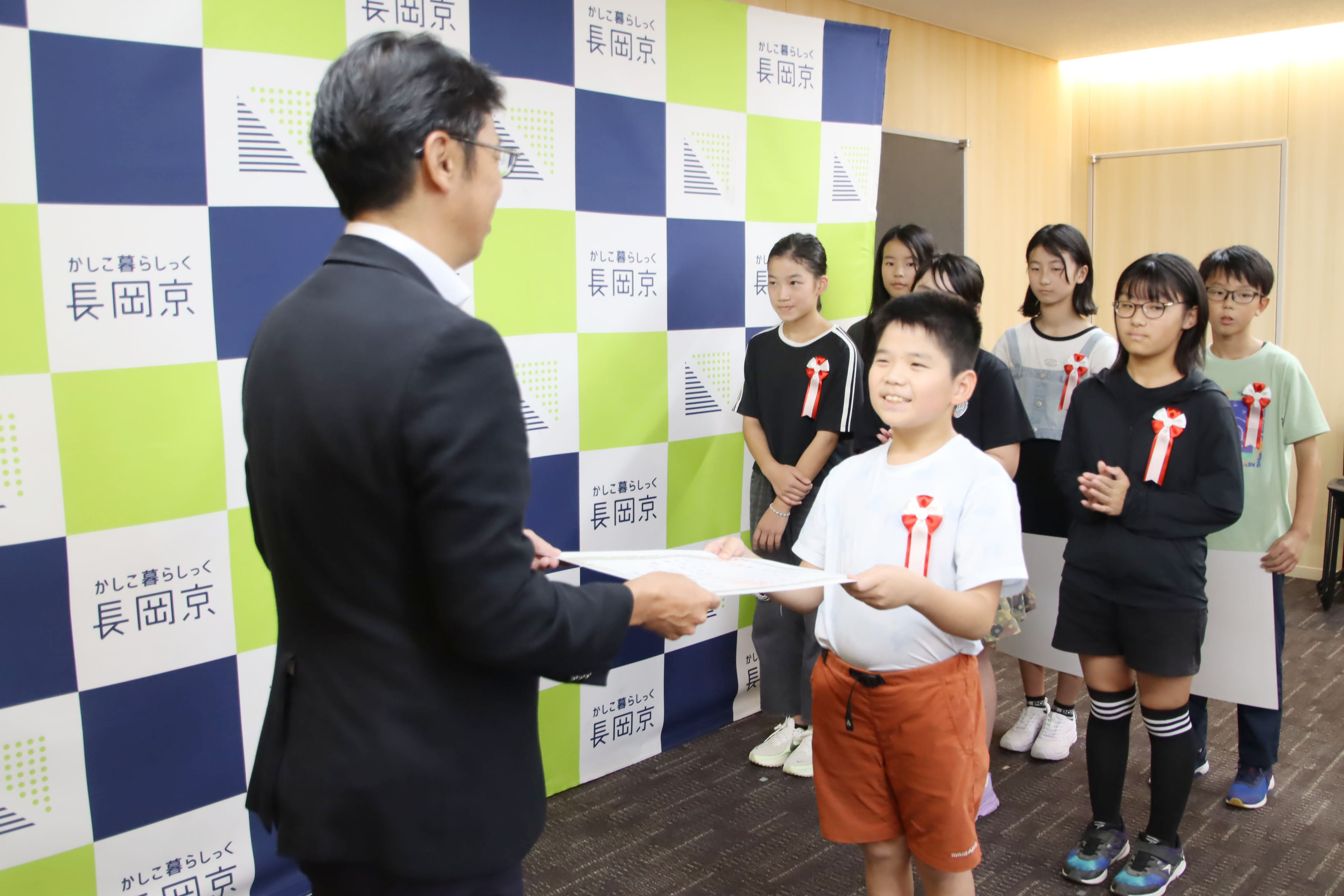 市長が小学生に表彰状を渡す様子