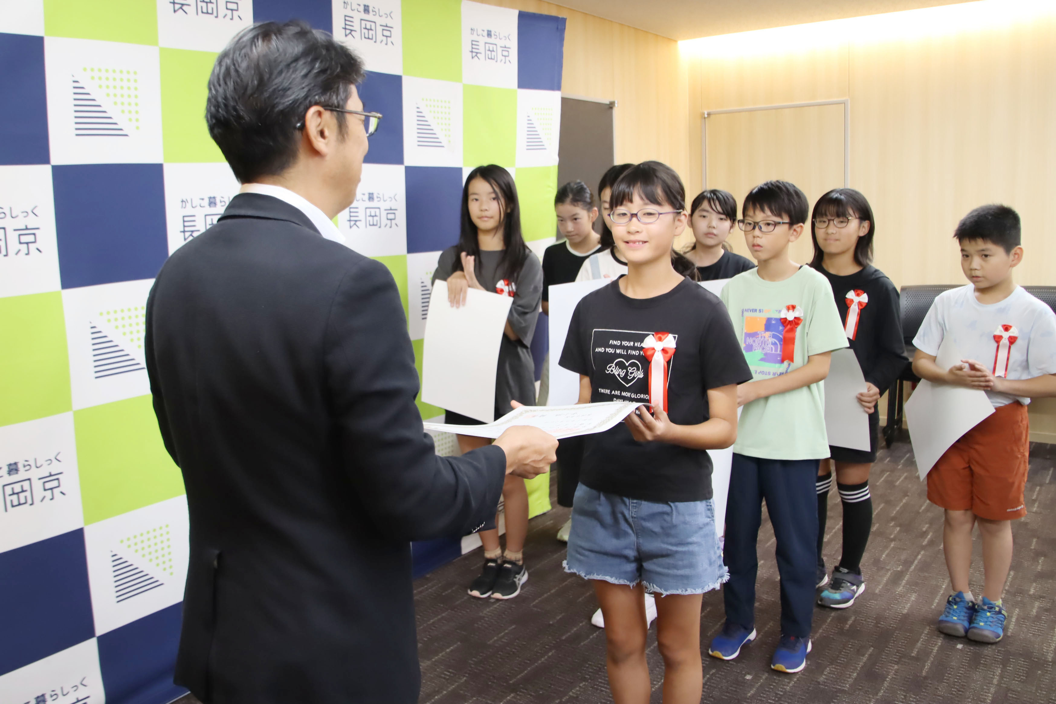 市長が小学生に表彰状を渡す様子