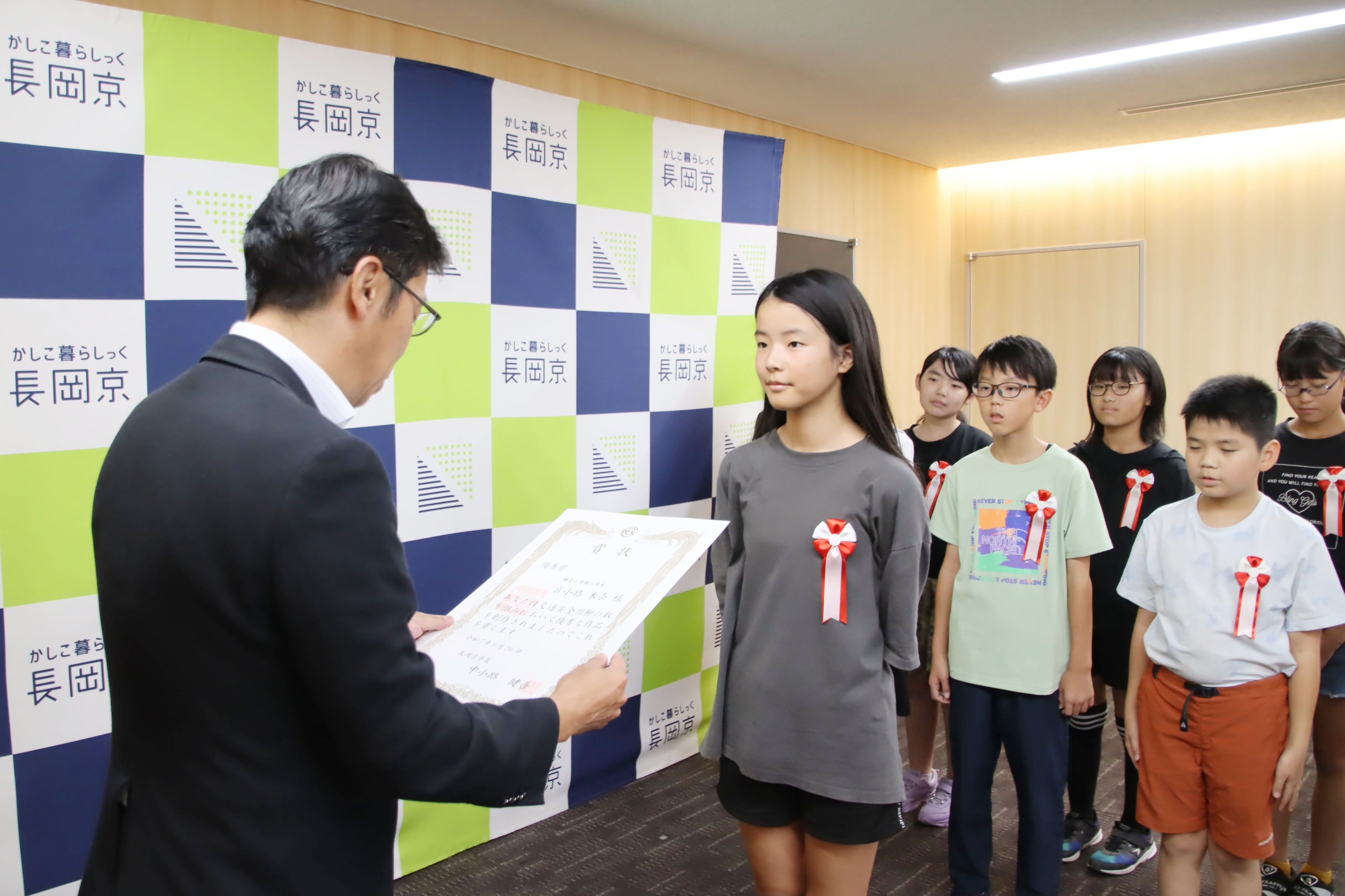 市長が小学生に表彰状を渡す様子