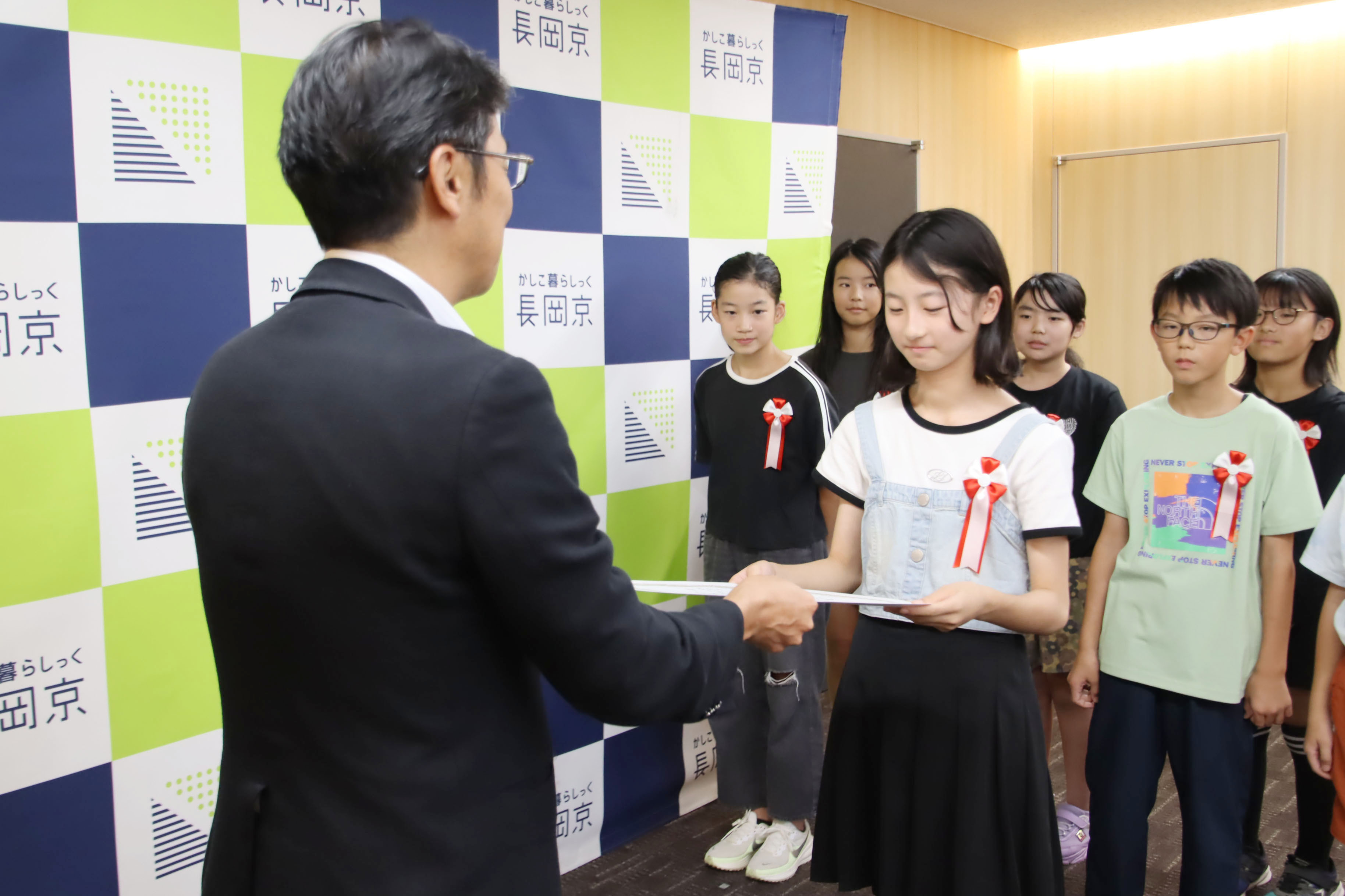 市長が小学生に表彰状を渡す様子