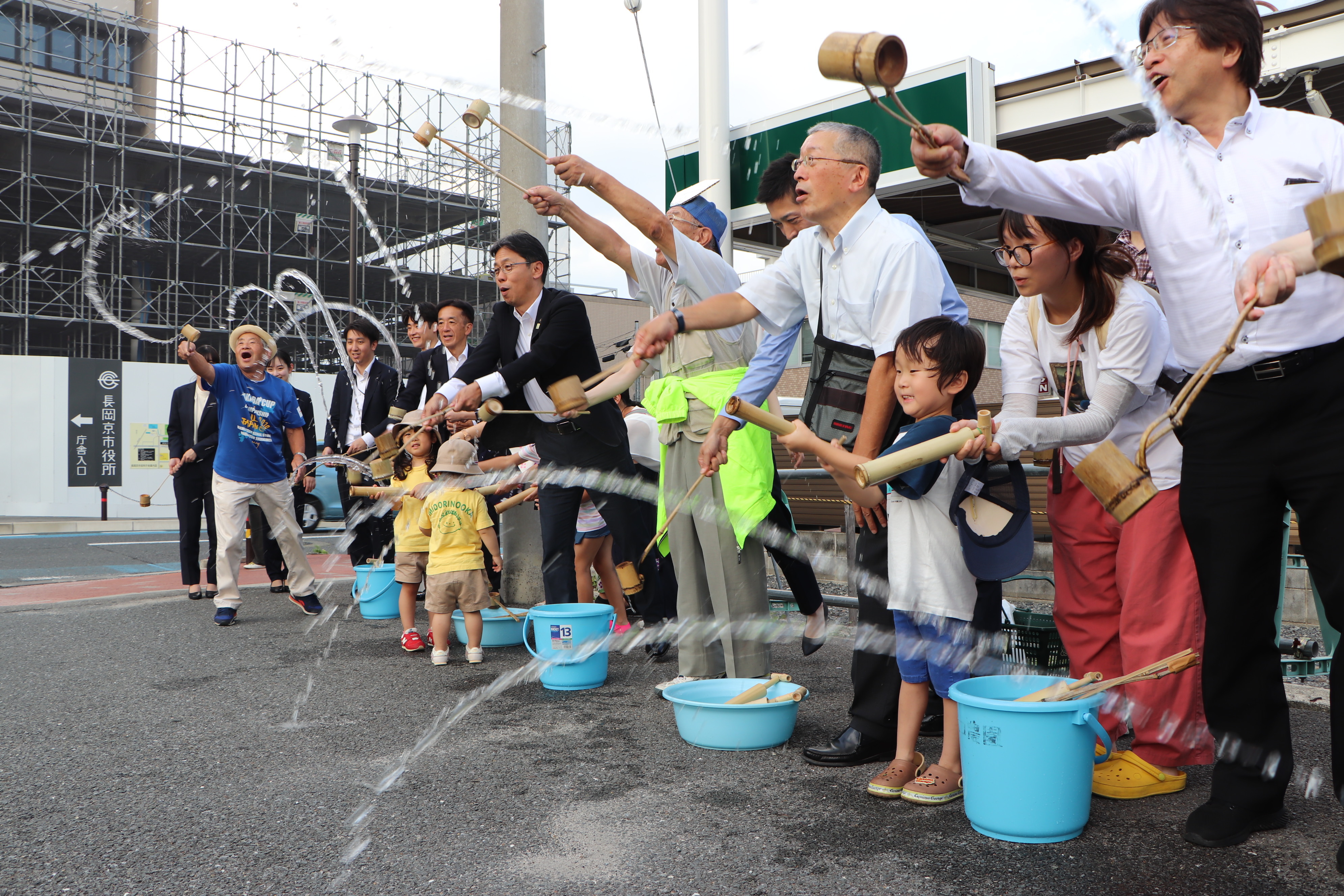 市役所南側駐車場前で打ち水をしている様子
