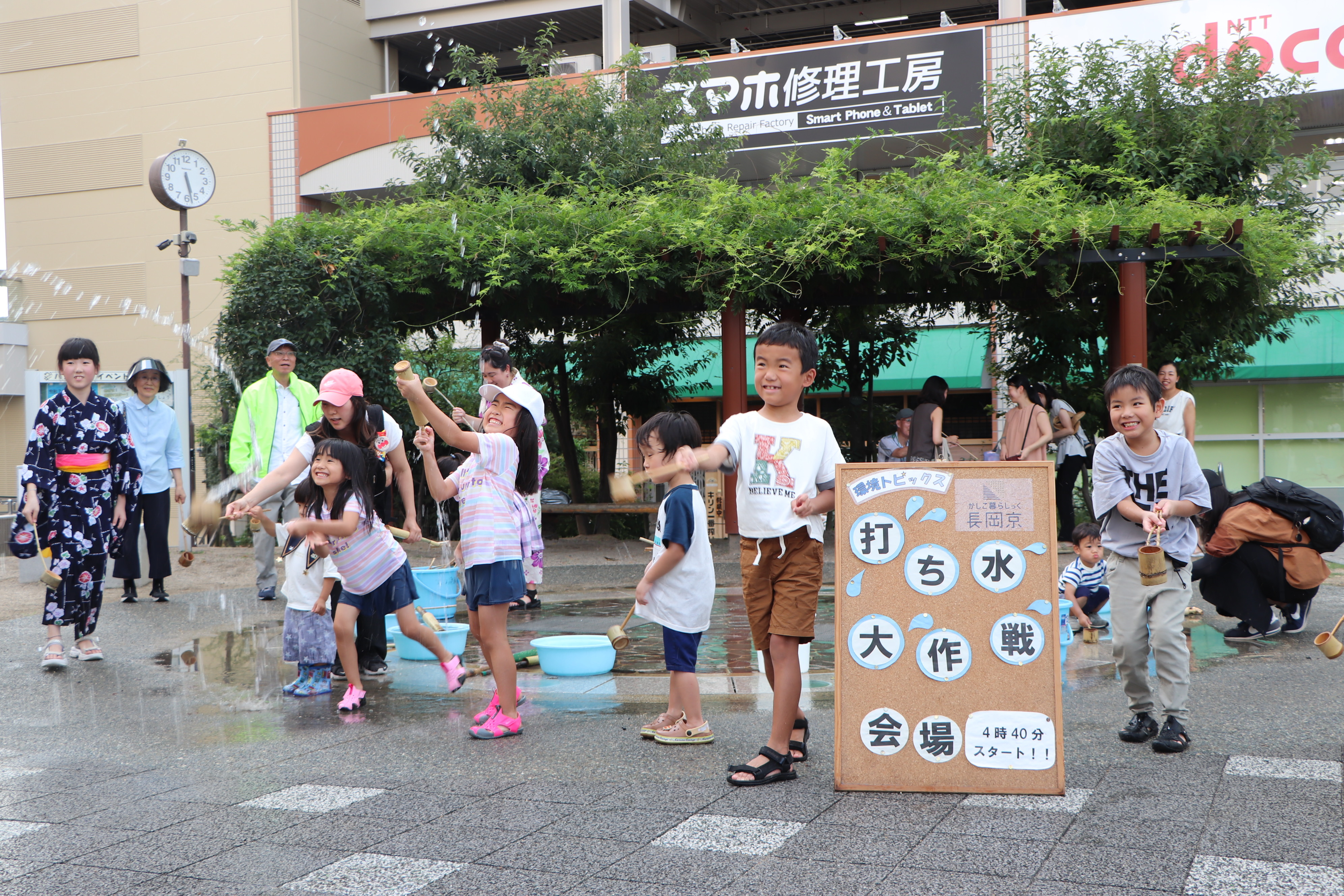 市役所南側駐車場前で打ち水をしている様子2